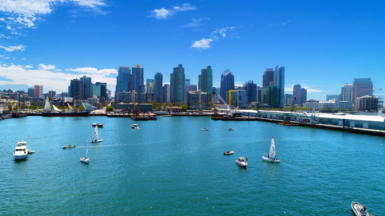 San Diego skyline and waterfront with sailboats on blue harbor water